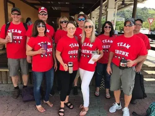 Group of friends wearing matching red custom shirts for a trip, an example of custom shirts with screen printing that can be fulfilled by SameDayCustom